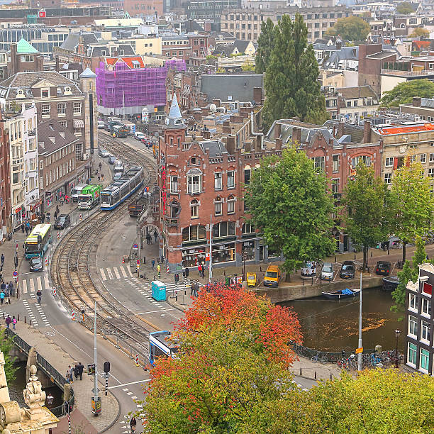 Amsterdam, Netherlands - October 6, 2014: Top view of red tiled roofs and promenade. Amsterdam is the Netherlands’ capital, known for its artistic heritage, elaborate canal system and narrow houses
