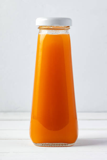 istock Small glass bottle of fresh juice on white background 2236733877