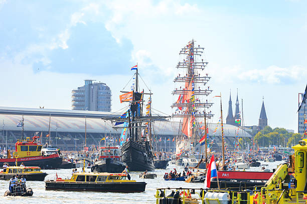 Amsterdam, Netherlands—Aug 24, 2025: magnificent tall ships and personal ships on IJ river during Sail Amsterdam 2025, central station in the background