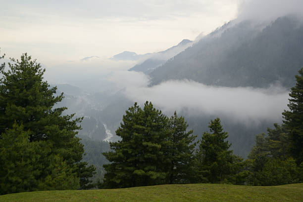 The Himalayas, shrouded in mist, create a beautiful view from Pahalgam, a place surrounded by lush pine forests in Jammu and Kashmir, India.