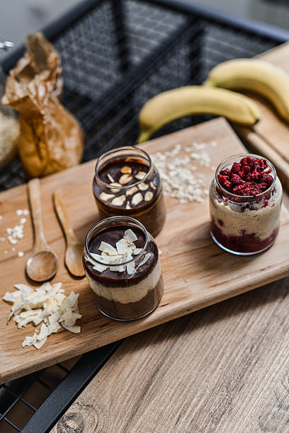 Glass Jars Filled With Different Overnight Oats Laid Out On Wooden Serving Board