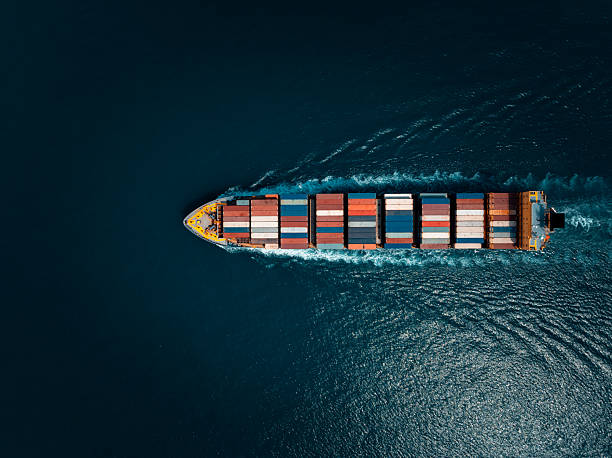 istock photograph of large container ship sailing on a deep sea, fully loaded with multi-colored containers, reflecting global maritime transport and logistics, cinematic dark tone  process. 2236742582