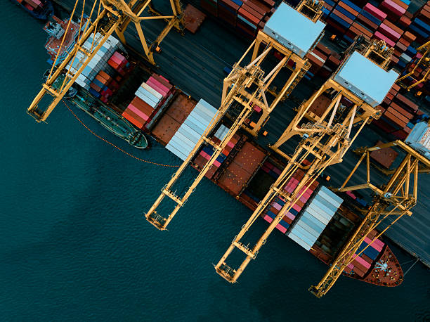 istock commercial port load and unloading cargo from container ship import export by crane for distributing goods by trailers transported to customers and dealers, 2236742783