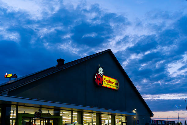 Ostrów Wielkopolski, Greater Poland Voivodeship, Poland - August 02, 2025 Building of popular Biedronka supermarket with distinctive logo and bright interior lights, evening retail architecture photography in Poland.