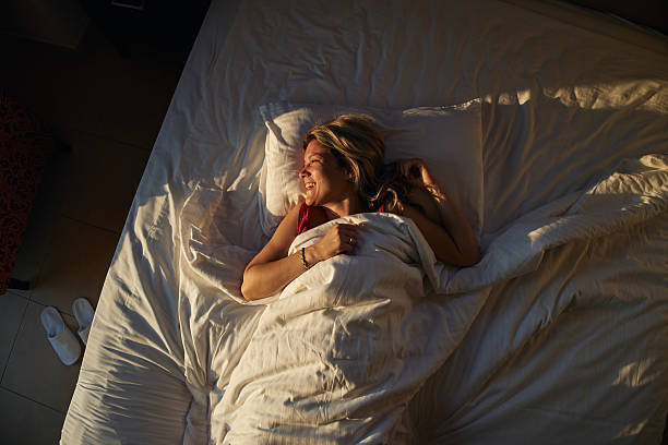 istock Woman waking up smiling feeling happy in bed 2236747624