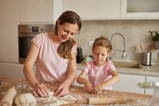 istock Mother and daughter making dough in the kitchen 2236748804
