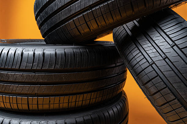 istock Car tires isolated on yellow background, close up 2236749106
