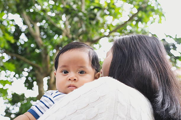 istock Mother carrying a baby under the trees 2236750871