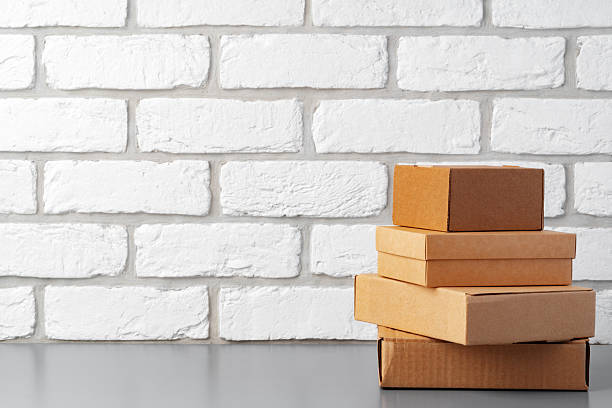 Cardboard boxes against white brick wall, close up photo