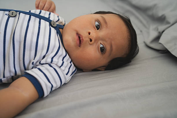 istock Baby lying on bed indoors looking curious and calm 2236751911