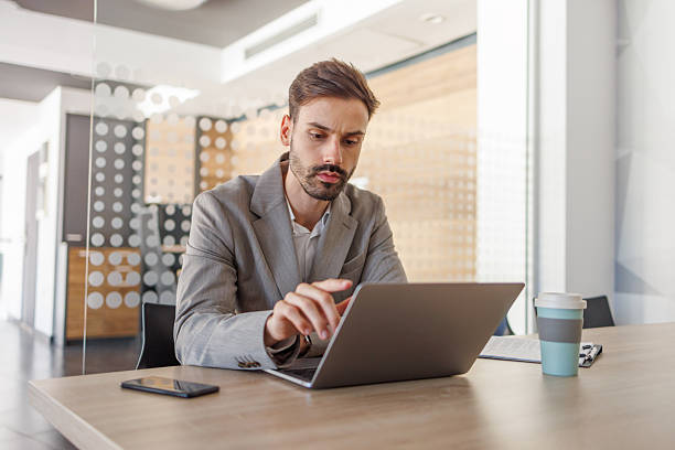 istock Focused businessman working on laptop in modern office environment 2236753811