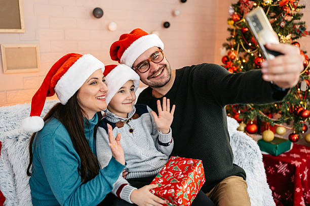 istock Mother And Father Taking Selfies Using Phone With Their Son On The Sofa At Home During Christmas Holidays 2236755044