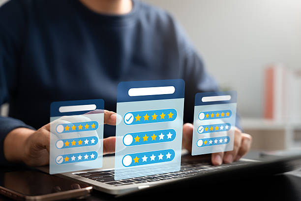 istock Customer feedback and rating system concept. Businessman using laptop to submit digital satisfaction survey with five-star rating, review form, and multiple choice evaluation interface. 2236755147