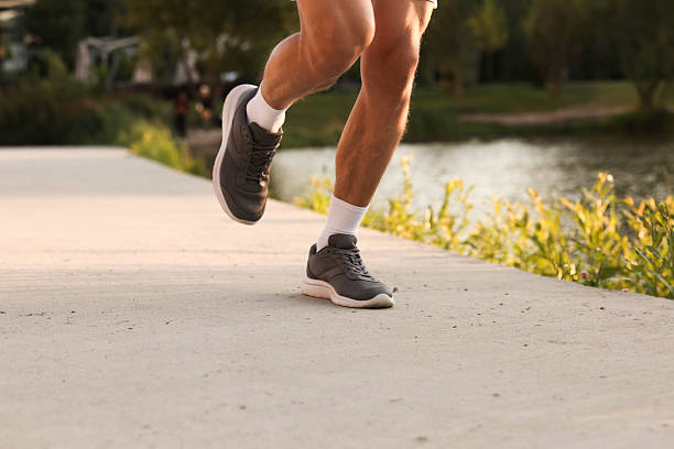 istock Athletic man running near lake in park, closeup 2236757421