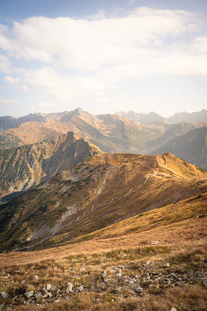 Autumn mountains scenery, high peak with autumn colors, blue sky. Located in Poland, near Kasprowy Wierch.