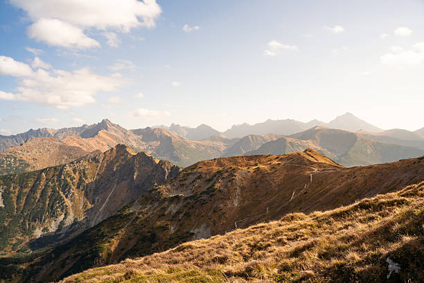 Autumn mountains scenery, high peak with autumn colors, blue sky. Located in Poland, near Kasprowy Wierch.