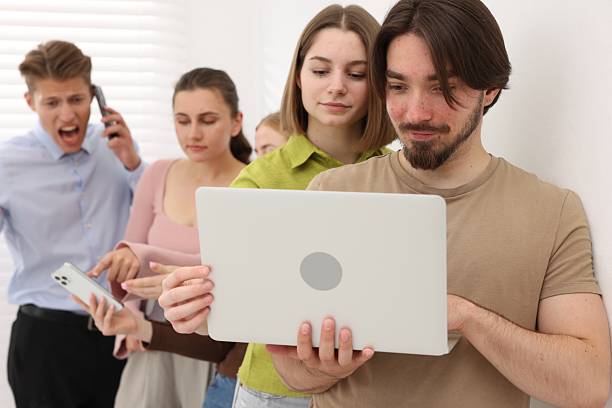 istock People with different devices waiting in queue near white wall indoors 2236758162