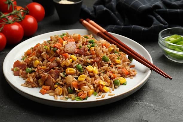 istock Delicious fried rice with vegetables and bacon served on grey table, closeup 2236759367