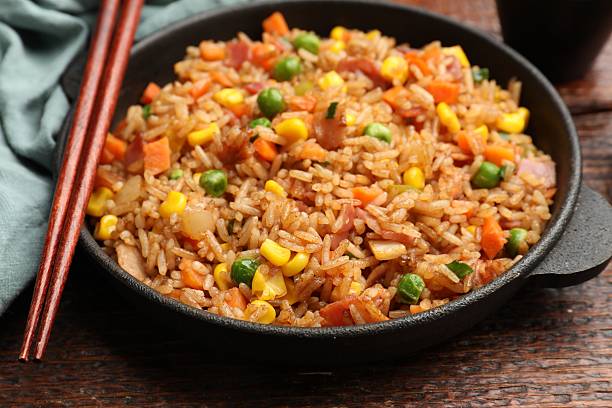 istock Delicious fried rice in baking dish served on wooden table, closeup 2236759412