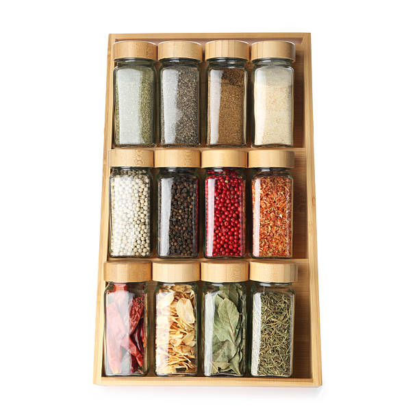 Different aromatic spices in glass jars isolated on white, top view