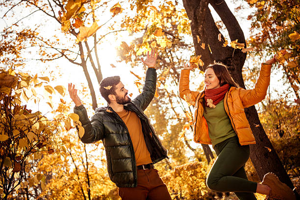 istock Couple joyfully enjoying autumn in a sunny park surrounded by vibrant fall foliage, expressing happiness and love 2236760785