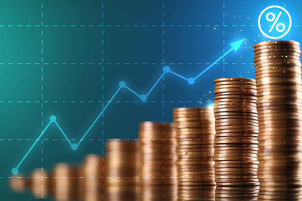 istock Percent sign and arrow above stacked coins against blue gradient background 2236761580