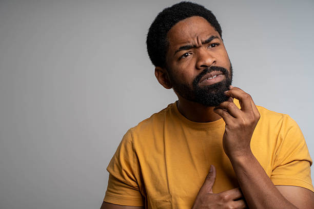 istock Thinking black man close up holding chin isolated on background 2236762519
