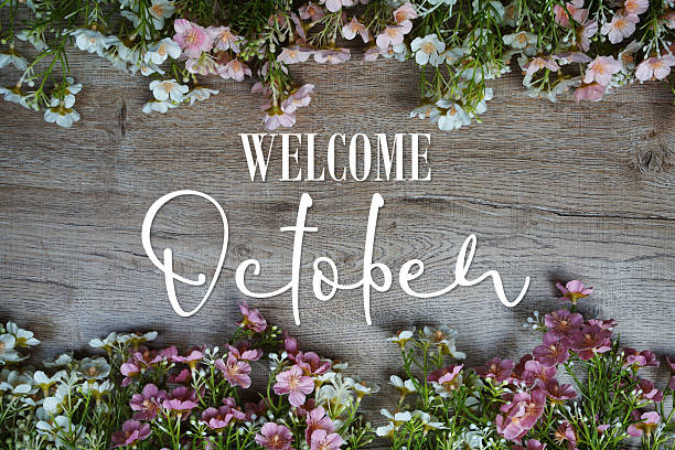 istock Welcome October text with flowers frame on wooden background 2236762786