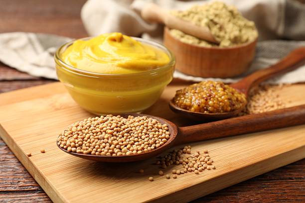 istock Different types of mustard on wooden table, closeup 2236764376