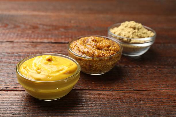 istock Different types of mustard on wooden table, closeup 2236764385