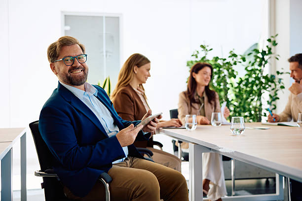 istock Smiling businessman leading diverse group meeting in modern office 2236766276