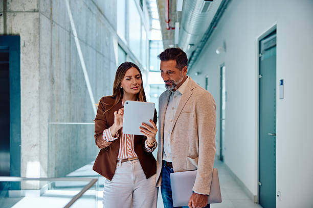 istock Business colleagues collaborating with digital tablet in modern office hallway 2236766744