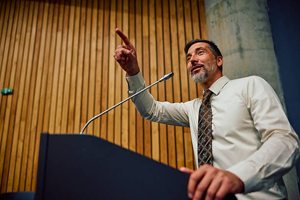 istock Confident mid adult man speaking at conference podium 2236767044