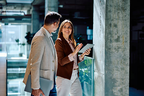 istock Mid adults collaborating with digital tablet in modern office space 2236767052