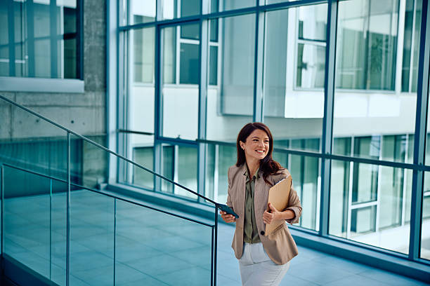 istock Confident young businesswoman walking inside modern office building 2236767136