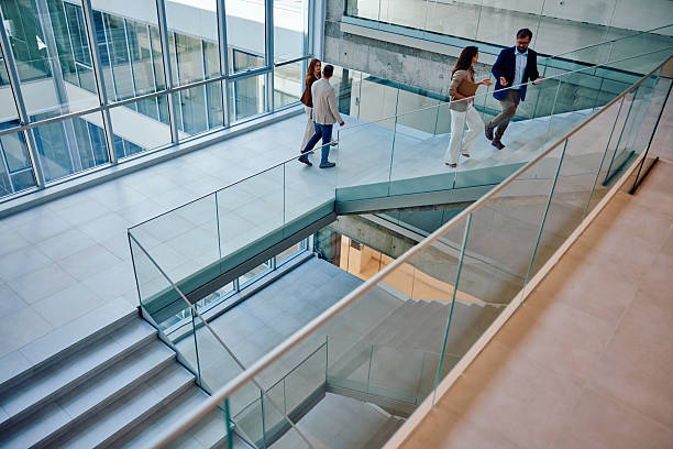 istock Modern business colleagues walking inside glass office building 2236767327