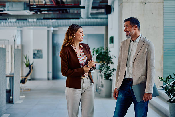 istock Successful colleagues having casual business conversation in modern office hallway 2236767348