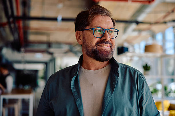 istock Confident mature man smiling in modern office workspace 2236767866