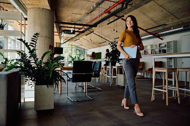istock Confident young businesswoman walking in modern office workspace 2236767908