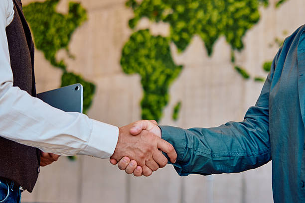 istock Business handshake partnership agreement with global sustainability background 2236768029