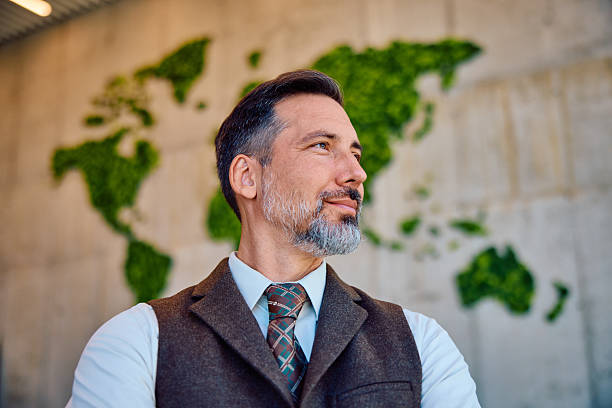 istock Confident mid adult businessman with world map background 2236768038