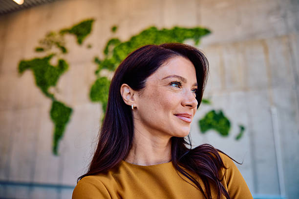 istock Confident young woman smiling indoors with world map backdrop 2236768088