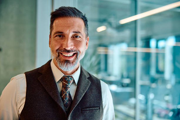 istock Confident mid adult businessman smiling in modern office setting 2236768247
