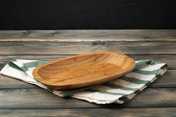 istock Wooden board with kitchen napkin on dark wooden table 2236768285
