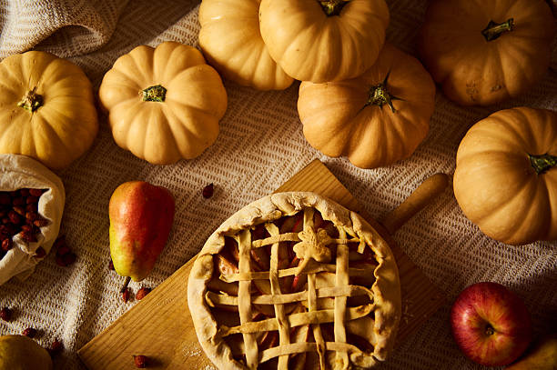 istock Autumn Harvest Scene With Pumpkins, Apples, and Lattice Pie on Rustic Table 2236769049