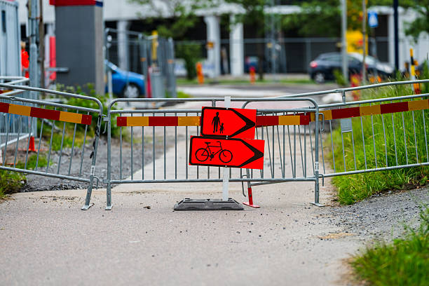 Barrier with red signs redirecting traffic path.