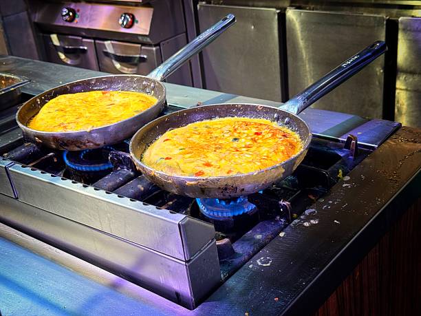 Traditional Spanish tortillas being cooked on a gas flame