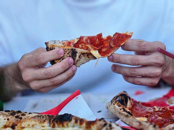 istock A slice of pizza in hands 2236778415