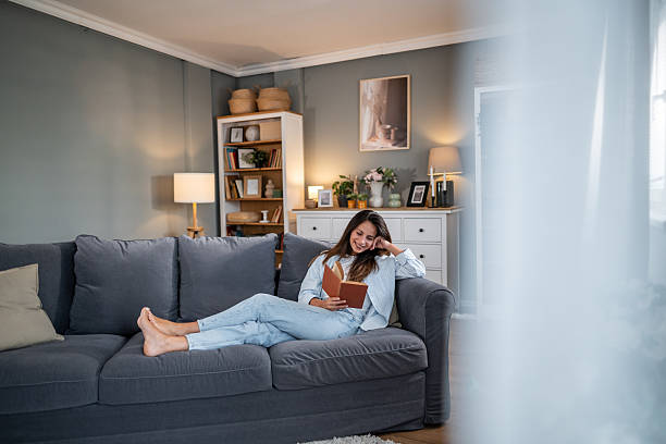 istock Relaxed young woman reading on comfortable modern sofa 2236780918
