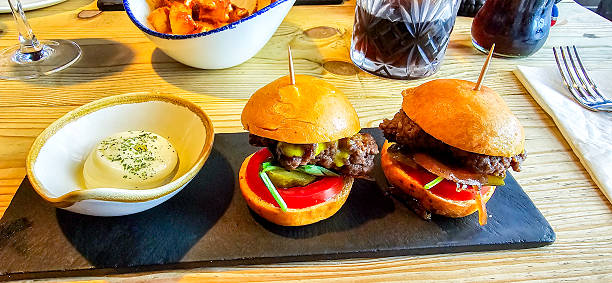 Two delicious mini beef burgers freshly cooked waiting for to be consumed.